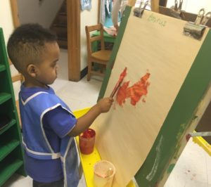 Boy painting at an easel